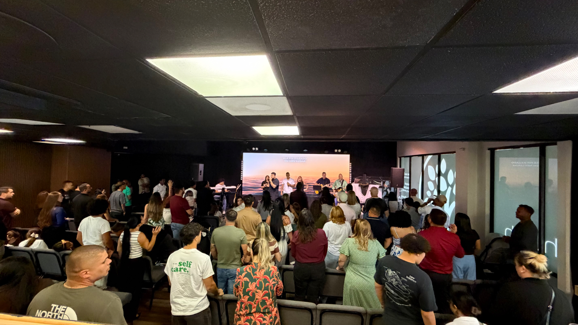 Igreja de pé em adoração no Culto de Celebração